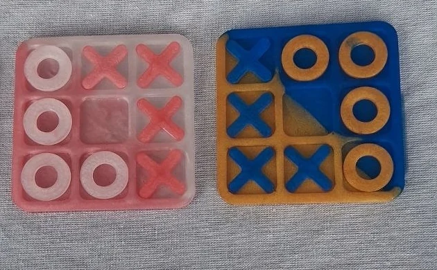 Two handmade resin tic-tac-toe boards with X and O playing pieces
